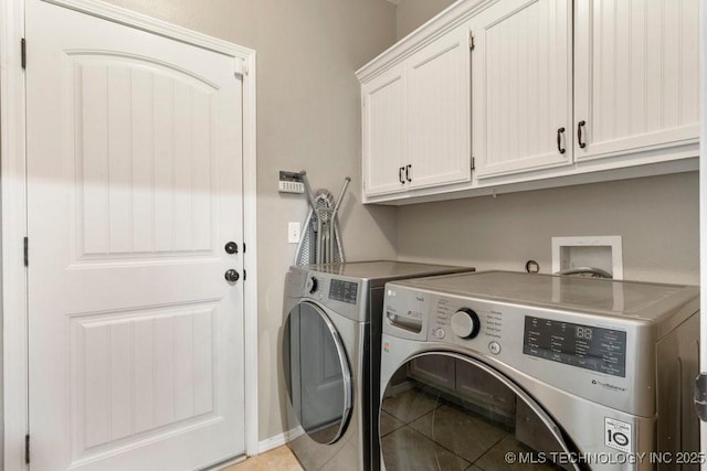 laundry room featuring cabinets, washing machine and dryer, and light tile patterned floors