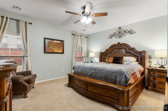 bedroom with visible vents, baseboards, multiple windows, and light colored carpet