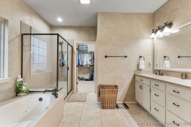 bathroom featuring a stall shower, a walk in closet, vanity, and tile patterned floors