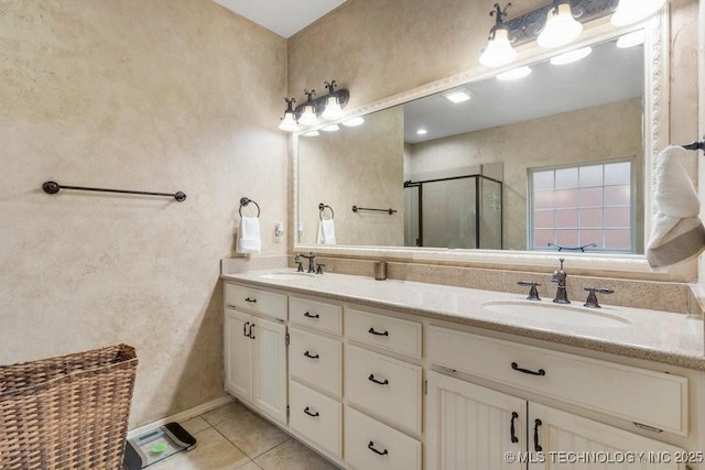 full bath with a sink, tile patterned floors, a shower stall, and double vanity