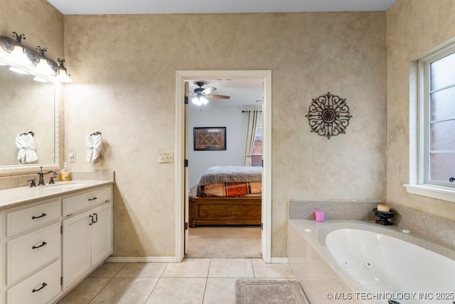 ensuite bathroom with a ceiling fan, connected bathroom, vanity, tile patterned flooring, and a tub with jets