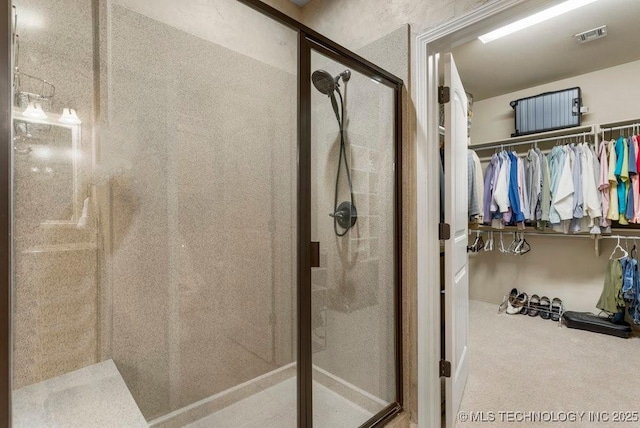 bathroom featuring a shower stall, visible vents, and a walk in closet