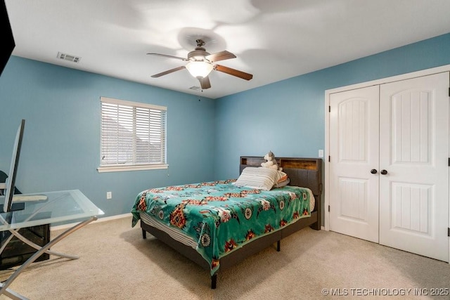 carpeted bedroom with visible vents, baseboards, ceiling fan, and a closet