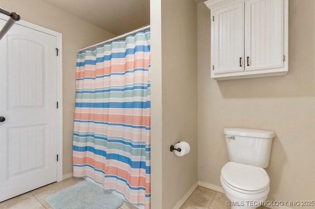 bathroom with baseboards, tile patterned floors, toilet, and curtained shower