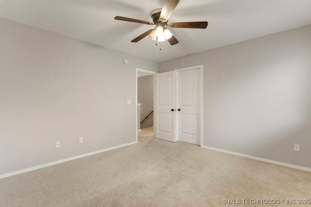 unfurnished bedroom featuring ceiling fan, light colored carpet, and a closet