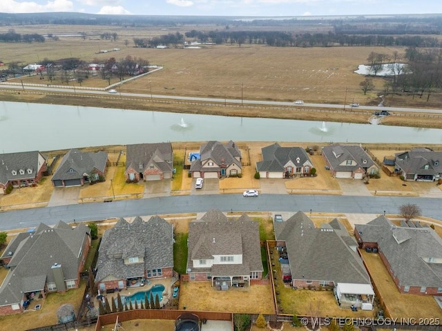 drone / aerial view with a water view and a residential view