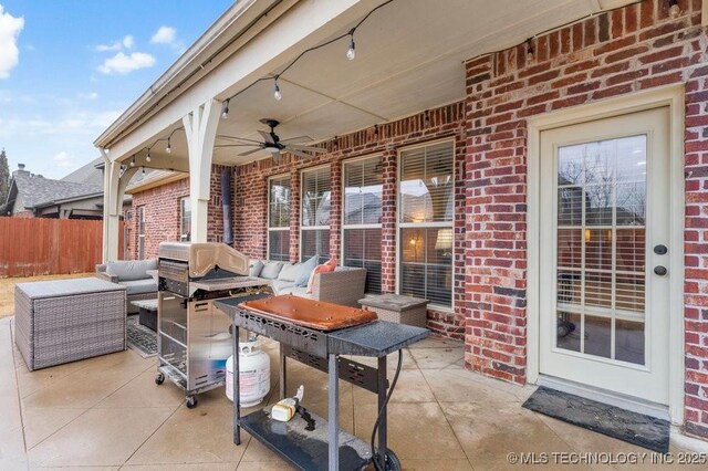 view of patio / terrace with a ceiling fan, fence, and an outdoor living space