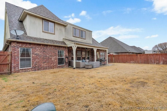 rear view of house with a fenced backyard, a shingled roof, an outdoor living space, and brick siding