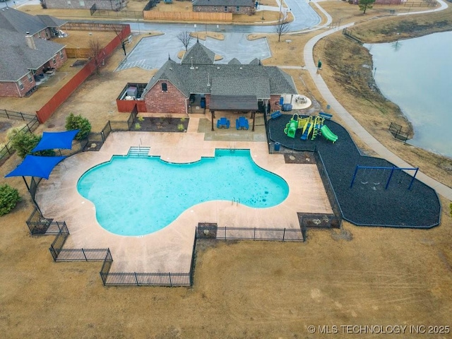 pool with fence, a water play area, a water slide, and a patio