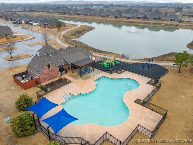 community pool featuring a residential view, a patio area, a water view, and fence