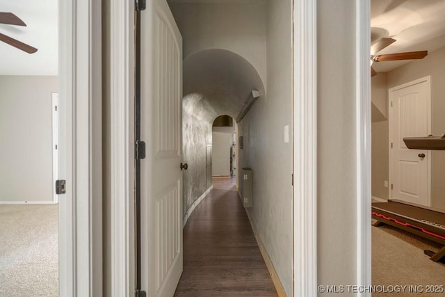 corridor with arched walkways and baseboards