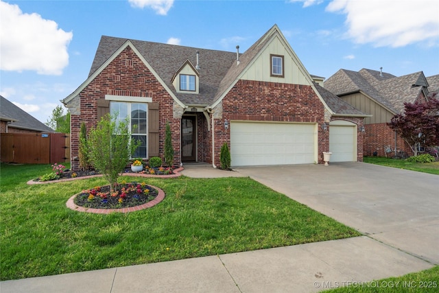 traditional-style house with fence, a front lawn, brick siding, a garage, and driveway