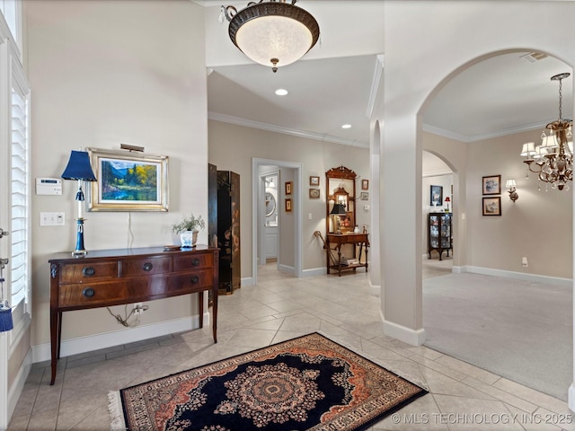 foyer entrance with crown molding, light tile patterned floors, and a chandelier
