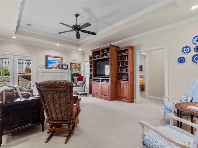 carpeted living room featuring a raised ceiling, ornamental molding, ceiling fan, and french doors