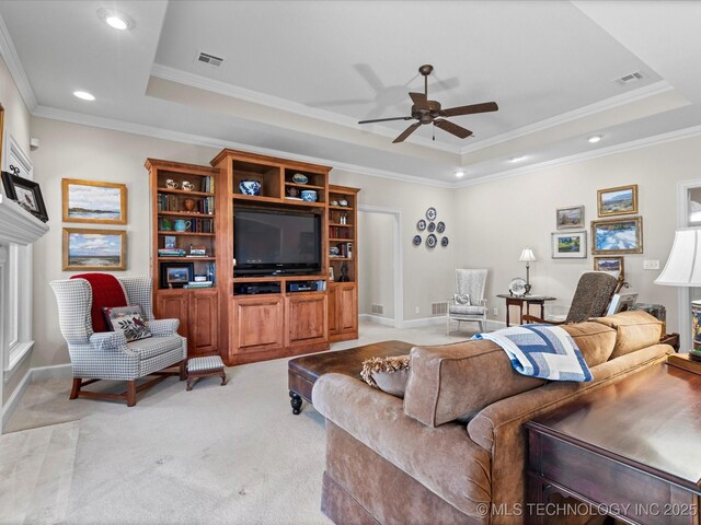 carpeted living room featuring ceiling fan, ornamental molding, and a raised ceiling