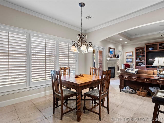 tiled dining space featuring an inviting chandelier and ornamental molding