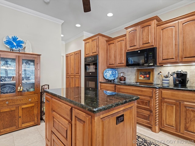 kitchen featuring decorative backsplash, dark stone counters, a center island, black appliances, and crown molding