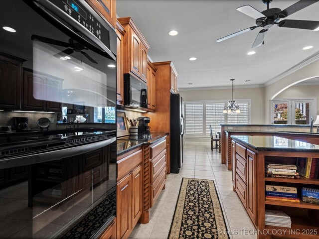 kitchen with light tile patterned floors, crown molding, tasteful backsplash, black appliances, and ceiling fan with notable chandelier