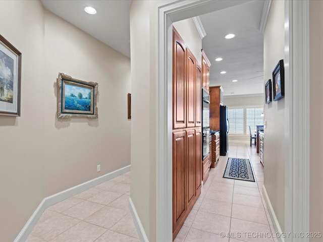 corridor featuring ornamental molding and light tile patterned floors