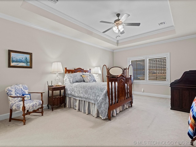 carpeted bedroom with crown molding, ceiling fan, and a tray ceiling