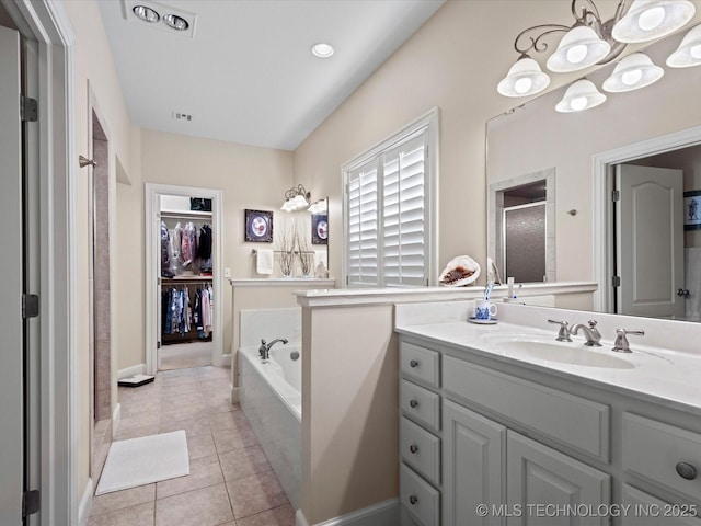2941 Versailles Pl, Bartlesville, OK 74006 - bathroom featuring a stall shower, a spacious closet, vanity, a bath, and tile patterned flooring