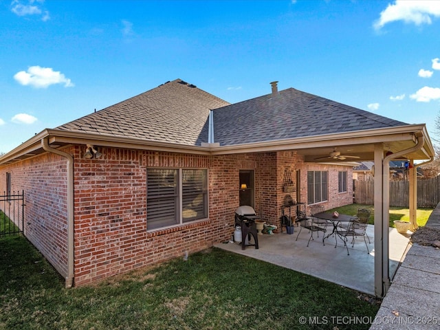back of property with ceiling fan, a yard, and a patio area