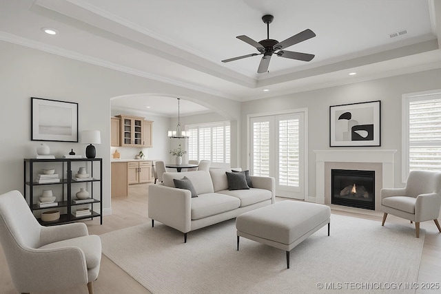 2941 Versailles Pl, Bartlesville, OK 74006 - living room with a raised ceiling, arched walkways, ceiling fan, recessed lighting, and light wood-type flooring