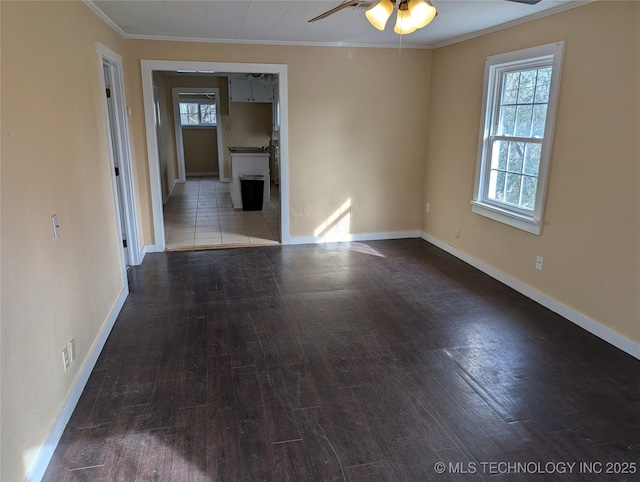 spare room with dark hardwood / wood-style flooring, ceiling fan, ornamental molding, and a healthy amount of sunlight