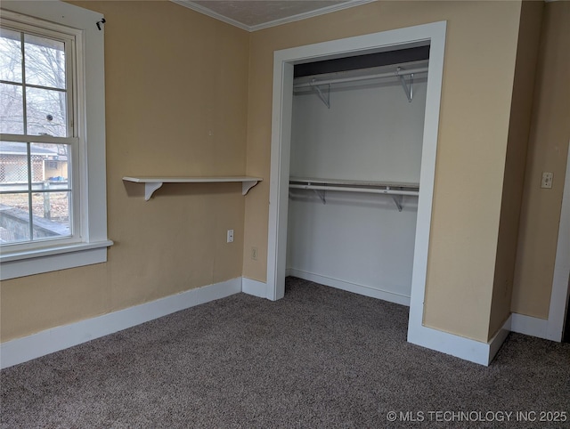 unfurnished bedroom featuring multiple windows, ornamental molding, a closet, and dark colored carpet