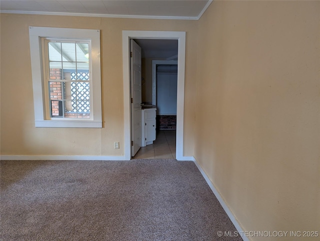 empty room with ornamental molding and light colored carpet