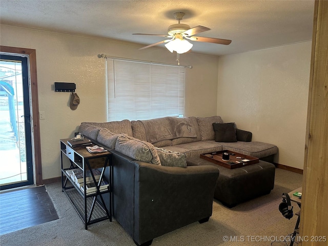 living room featuring ceiling fan and a textured ceiling