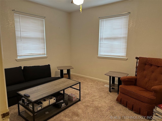 living area featuring ornamental molding and light carpet