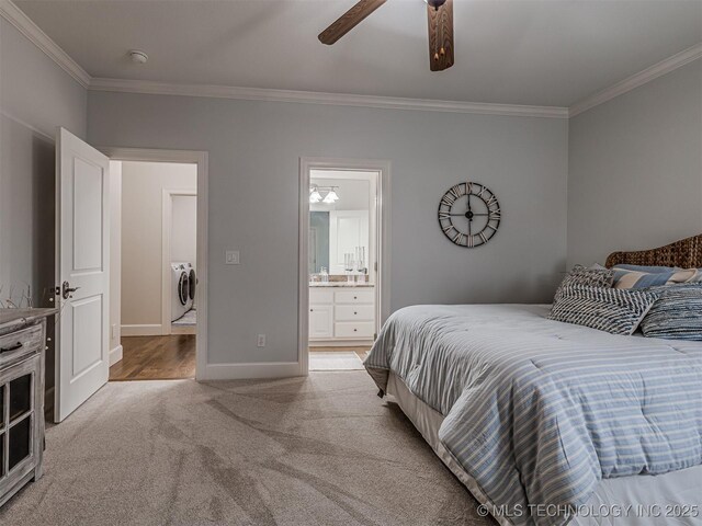 carpeted bedroom featuring crown molding, ensuite bathroom, ceiling fan, and washing machine and dryer