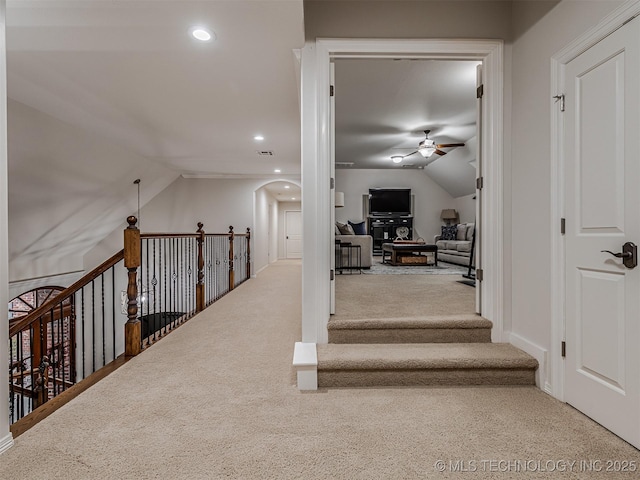 hallway with vaulted ceiling and carpet flooring