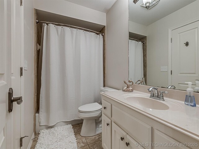 bathroom featuring vanity, tile patterned floors, and toilet