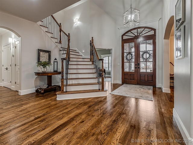 foyer featuring an inviting chandelier, hardwood / wood-style flooring, french doors, and a high ceiling