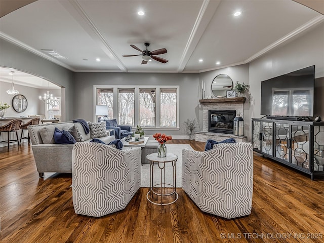 living room featuring crown molding, a fireplace, and dark hardwood / wood-style floors