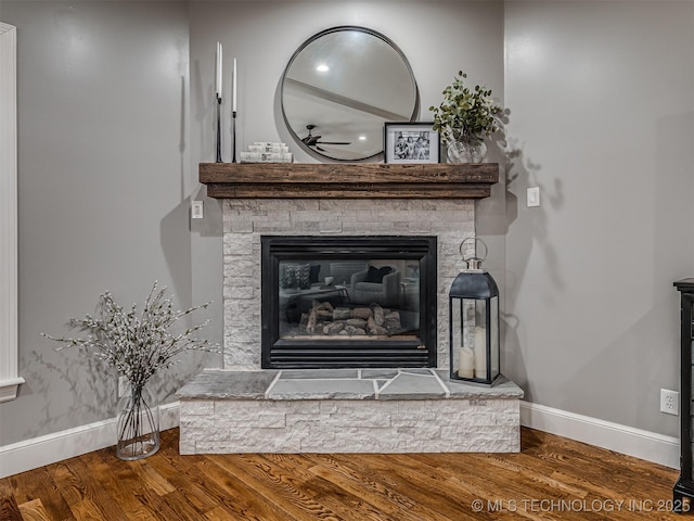 room details with hardwood / wood-style floors and a stone fireplace