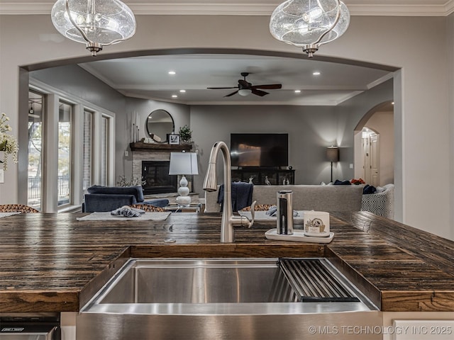 kitchen with crown molding, sink, ceiling fan, and decorative light fixtures