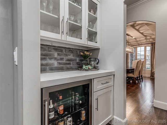 bar featuring wine cooler, dark hardwood / wood-style floors, decorative backsplash, and white cabinets