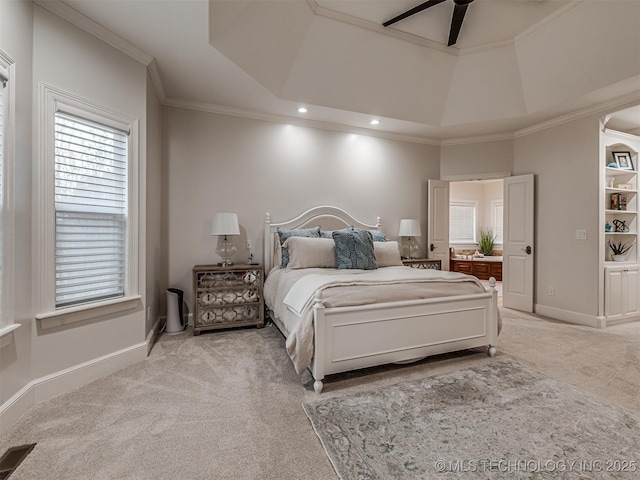 bedroom with light colored carpet, ornamental molding, and a tray ceiling