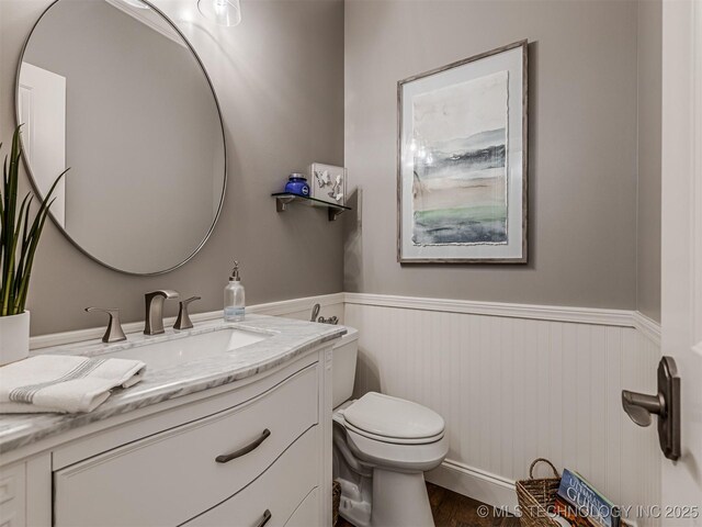 bathroom featuring vanity, wood-type flooring, and toilet