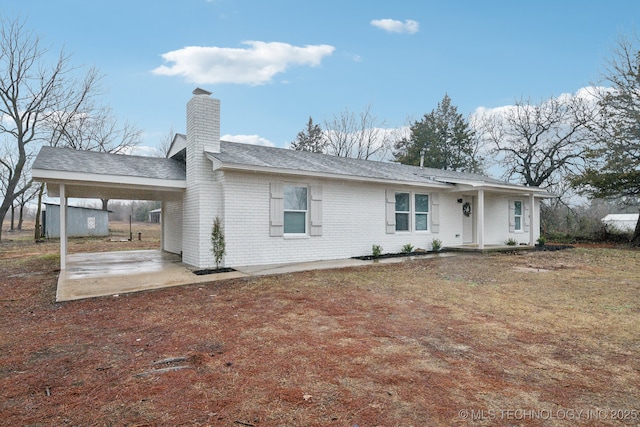 rear view of house featuring a carport and a yard