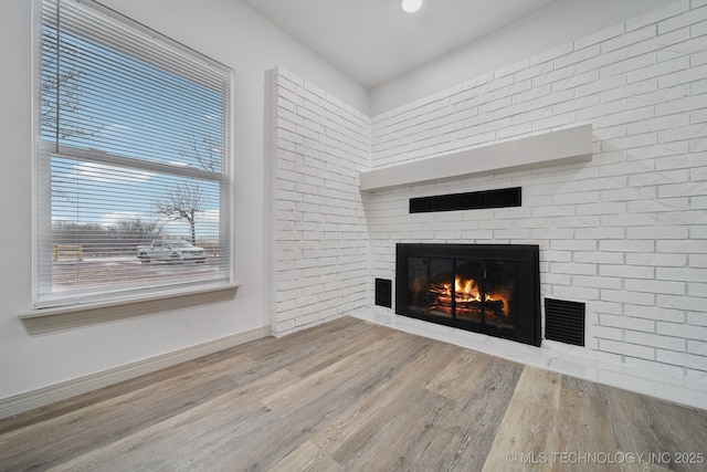 unfurnished living room featuring hardwood / wood-style flooring and a fireplace