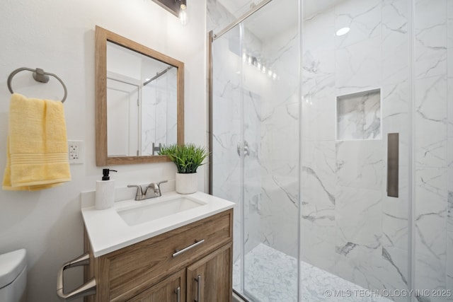 bathroom featuring an enclosed shower, vanity, and toilet