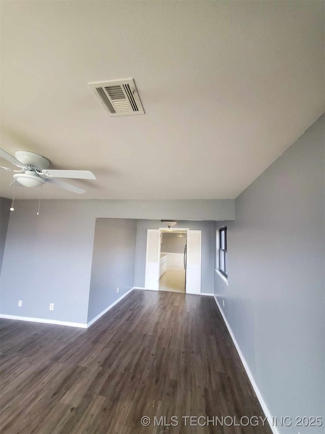 unfurnished room featuring dark wood-type flooring and ceiling fan