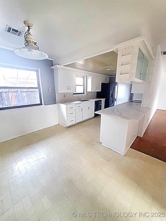 kitchen with decorative light fixtures, black dishwasher, kitchen peninsula, and white cabinets