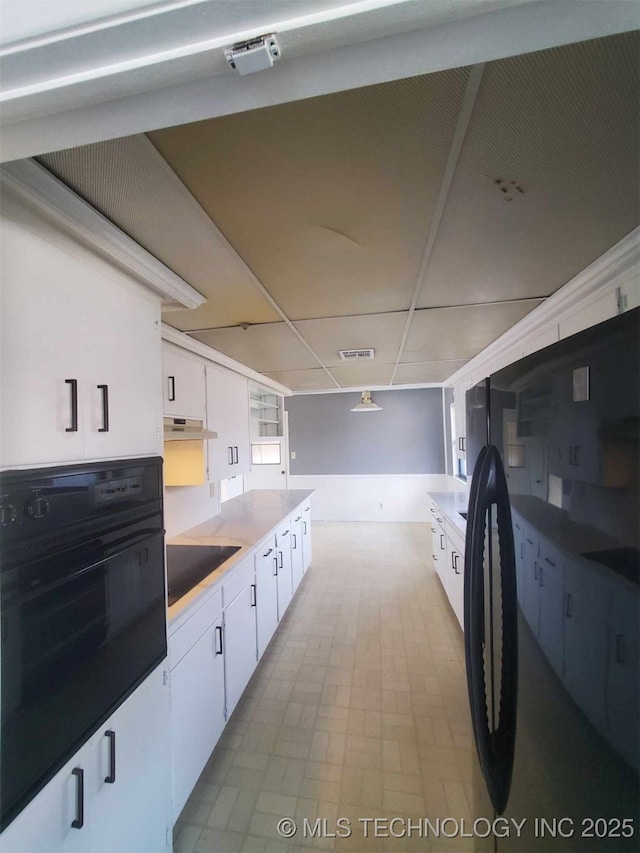 kitchen featuring white cabinetry, a paneled ceiling, and black appliances