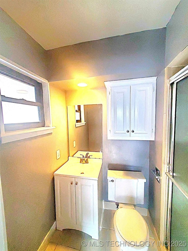 bathroom featuring an enclosed shower, sink, tile patterned floors, and toilet