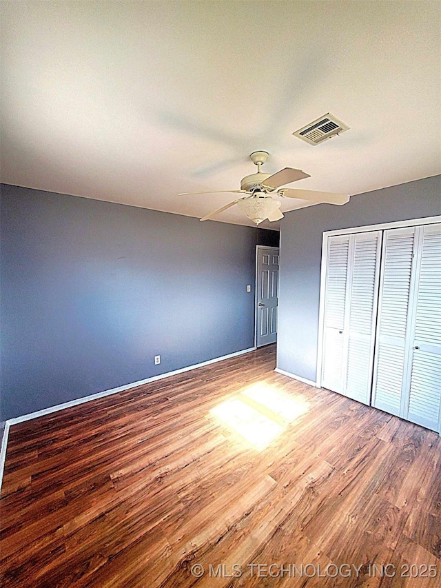 unfurnished bedroom featuring wood-type flooring, a closet, and ceiling fan